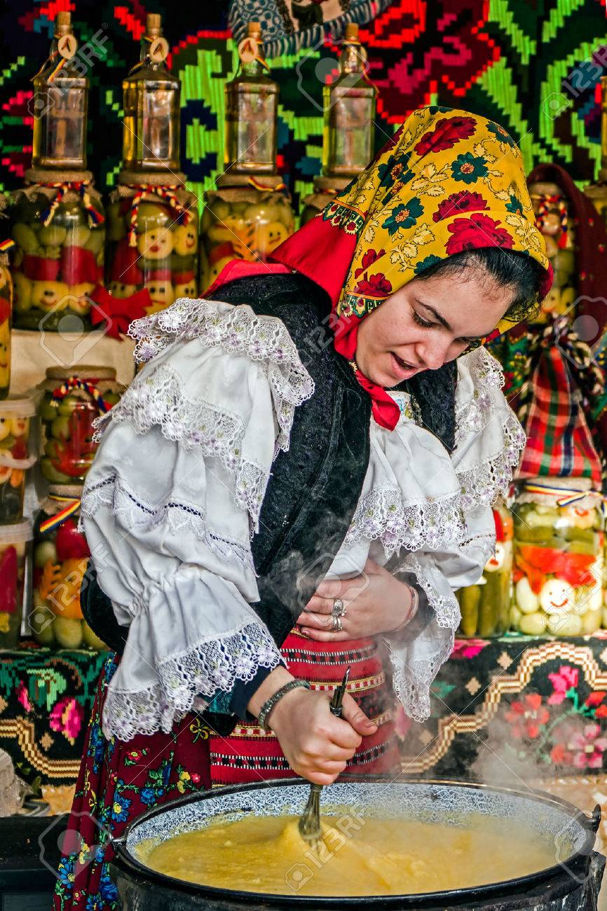 Young woman dressed in traditional costume from Maramures, Romania, mixed polenta in a large pot on a background with traditional embroidery.Street winter Fair in Timisoara, Romania, December 2014. - 36749781 Young woman dressed in traditional costume from Maramures, Romania, mixed polenta in a large pot on a background with traditional embroidery.Street winter Fair in Timisoara, Romania, December 2014. - 36749781