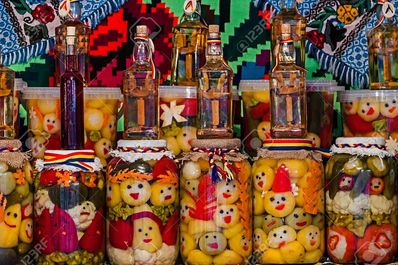 Jars with pickles and bottles with alcohol, traditional from area Maramures, Romania, displayed on a background with traditional embroidery. - 37435143 Jars with pickles and bottles with alcohol, traditional from area Maramures, Romania, displayed on a background with traditional embroidery. - 37435143