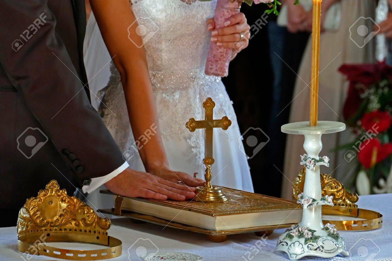 Groom and bride swear with hand on bible faith in marriage in a church. - 40975461 Groom and bride swear with hand on bible faith in marriage in a church. - 40975461