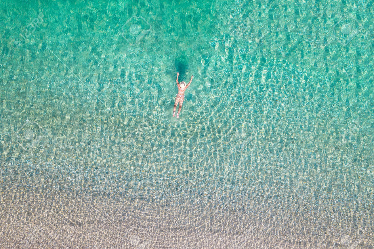 Top View. Young Beautiful Nudist Woman With Naked Breast Lying In Sea  Water. Drone, Copter Photo. Summer Holiday. View From Above. Stock Photo,  Picture and Royalty Free Image. Image 189217234.