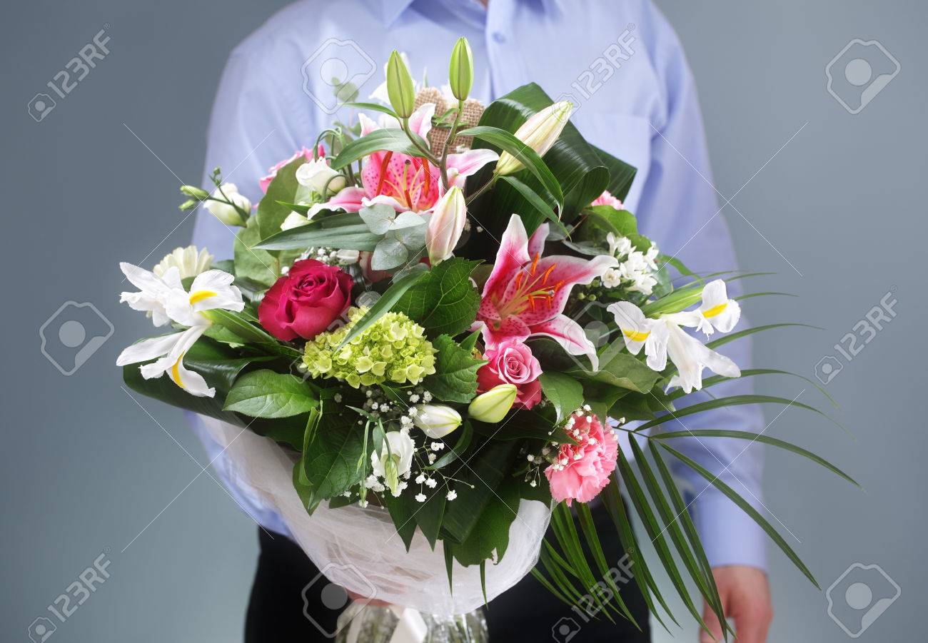 businessman holding and giving a bouquet of flowers stock photo