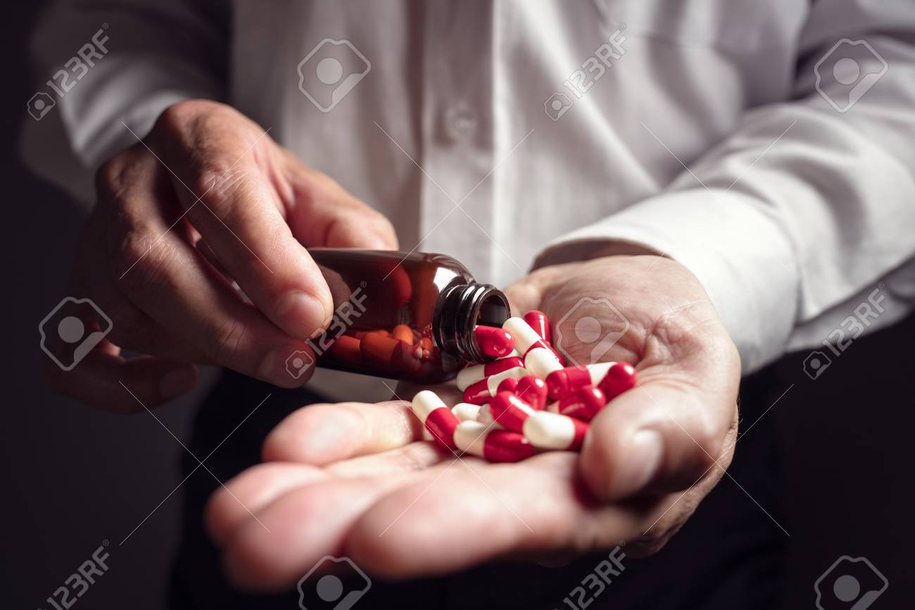 Pouring prescription drugs capsules from a pill bottle into hand - 87884676 Pouring prescription drugs capsules from a pill bottle into hand - 87884676