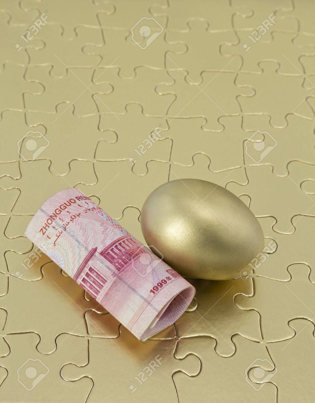 골드 퍼즐 조각에 배치 중국 돈과 반짝 둥지 계란 경제 위기 용액 또는 투자자 단순히 좋은 전략의 일환으로 아시아 투자를 반영합니다.  투자 성공을위한 퍼즐의 조각이다. 로열티 무료 사진, 그림, 이미지 그리고 스톡포토그래피.