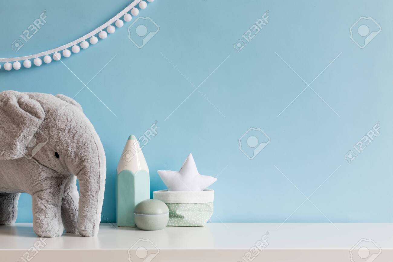 Cozy scandinavian newborn baby room with gray plush elephant ,white stars lamp and children accessories. Stylish interior with blue walls and haniging white garland. Template. Copy space. - 126277365 Cozy scandinavian newborn baby room with gray plush elephant ,white stars lamp and children accessories. Stylish interior with blue walls and haniging white garland. Template. Copy space. - 126277365