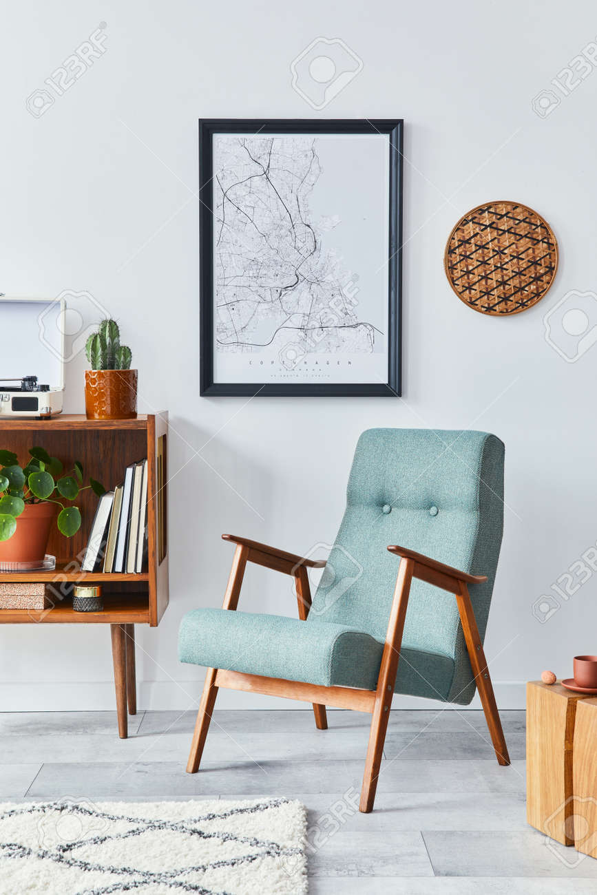 Retro composition of living room interior with mock up poster map, wooden shelf, book, stool, armchair, plant, cacti, vinyl recorder and personal accessories in stylish home decor. - 168356127 Retro composition of living room interior with mock up poster map, wooden shelf, book, stool, armchair, plant, cacti, vinyl recorder and personal accessories in stylish home decor. - 168356127