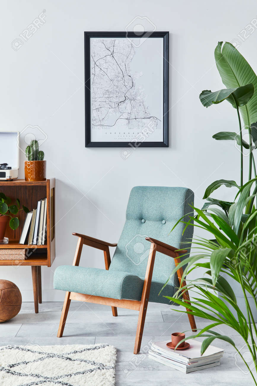 Stylish interior of living room with design wooden shelf, retro armchair, plants, mock up poster map, decoration, book, cacti and personal accessories in retro home decor. Template. - 168356618 Stylish interior of living room with design wooden shelf, retro armchair, plants, mock up poster map, decoration, book, cacti and personal accessories in retro home decor. Template. - 168356618