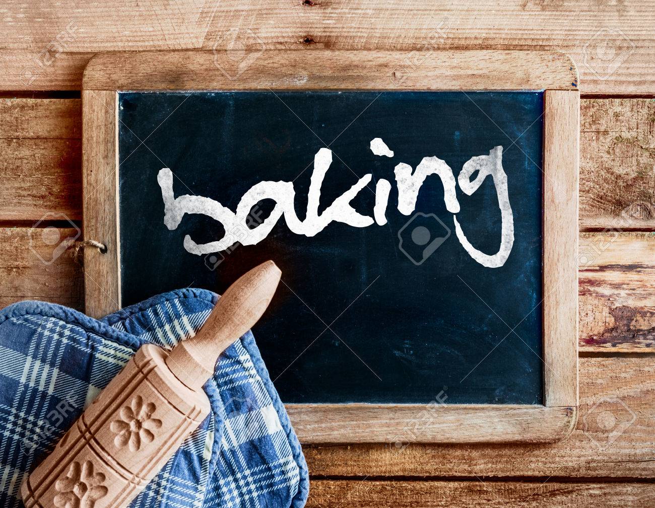装飾的な彫刻が施された木製めん棒で手書きの単語 ベーキングを苦しめられた木製フレームを使用して 古いビンテージ学校スレートに横たわってオーブン手袋花柄の国の台所 の写真素材 画像素材 Image