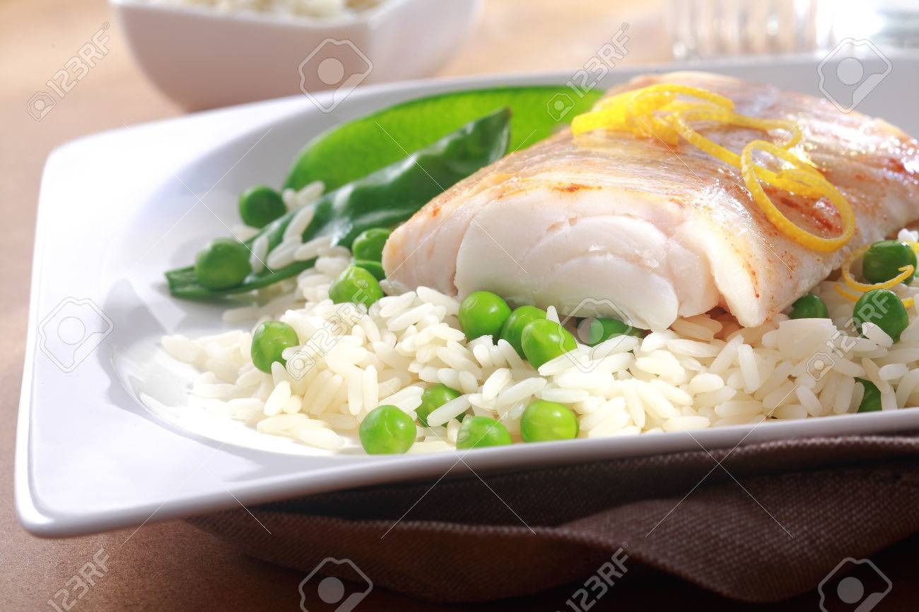 Comida Sana Del Filete De Pescado Al Horno Con Guarnición De Limón Fresco Ralladura Arroz Y Guisantes Servido En Un Plato Blanco Fotos Retratos Imágenes Y Fotografía De Archivo Libres De Derecho