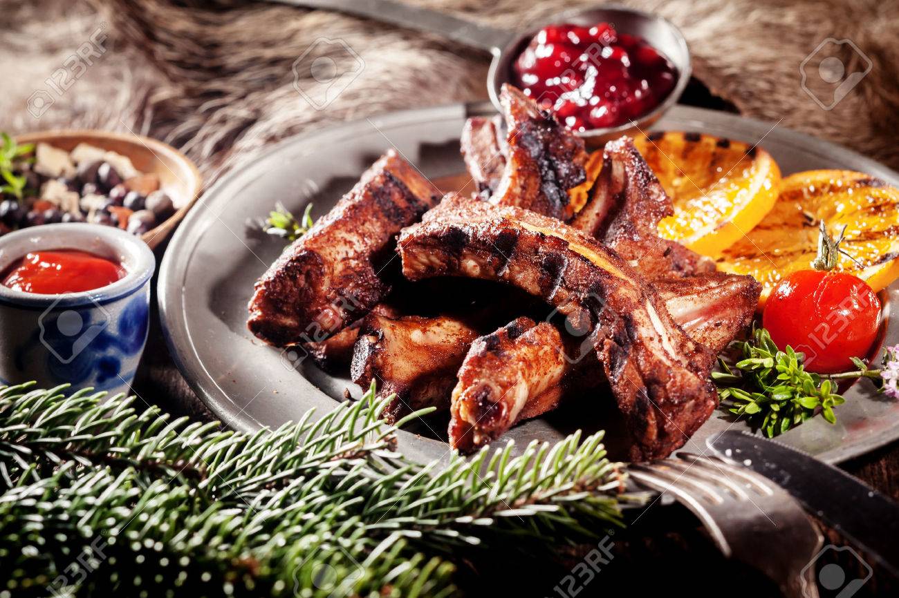 40504480-appetizing-bbq-boar-spare-ribs-with-grill-marks-served-on-platter-with-grilled-fruit-and-sauces.jpg