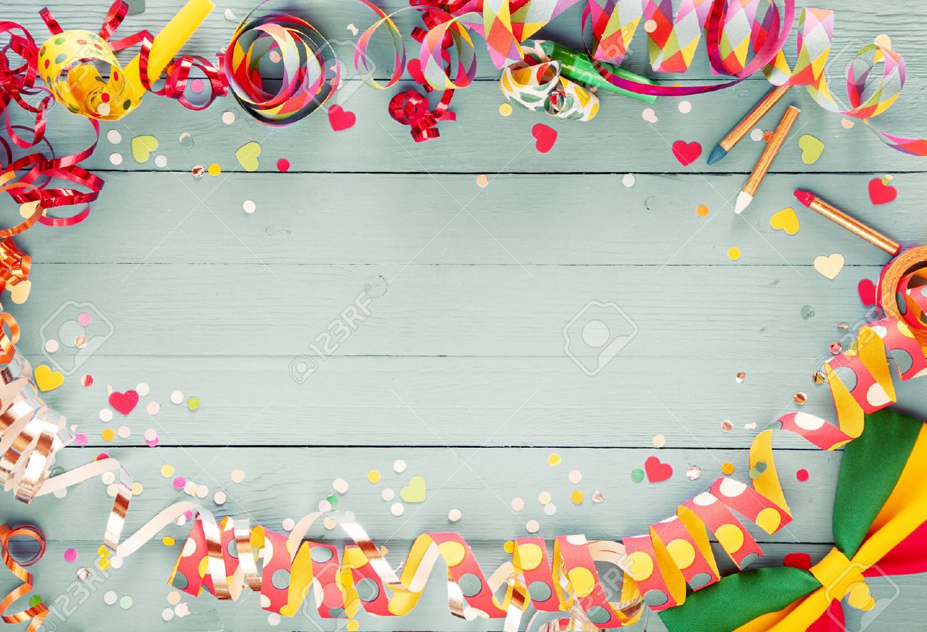 Colorful party frame with streamers and confetti and a vibrant bow tie in a corner around central copy space on a rustic wooden background - 51721201 Colorful party frame with streamers and confetti and a vibrant bow tie in a corner around central copy space on a rustic wooden background - 51721201