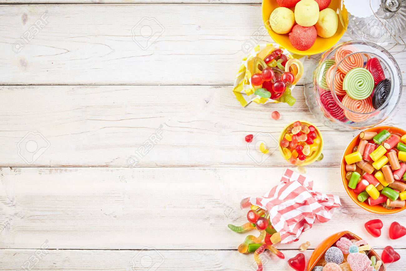 Overhead view of bowls filled with candy and other yummy confections beside glass jar with rolled licorice - 57822448 Overhead view of bowls filled with candy and other yummy confections beside glass jar with rolled licorice - 57822448