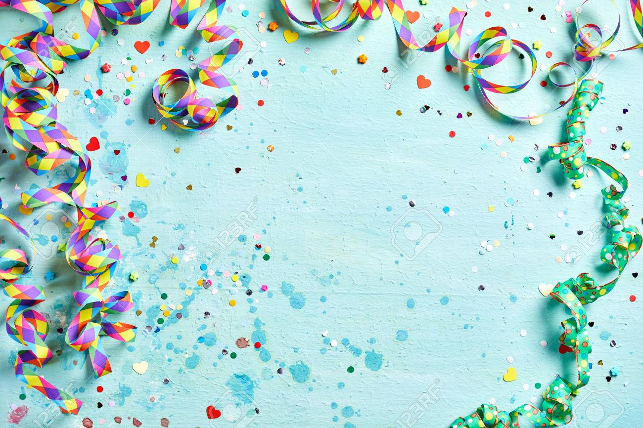 Festive party or carnival border of coiled streamers and confetti on a light blue green wood background with copy space - 69278499 Festive party or carnival border of coiled streamers and confetti on a light blue green wood background with copy space - 69278499