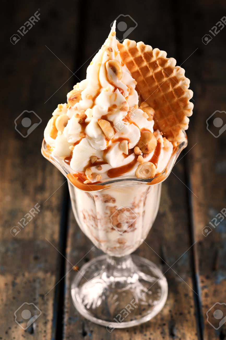 Delicious Ice Cream Sundae With Flake And Brown Sauce On Wooden Stock Photo Picture And Royalty Free Image Image 76186008