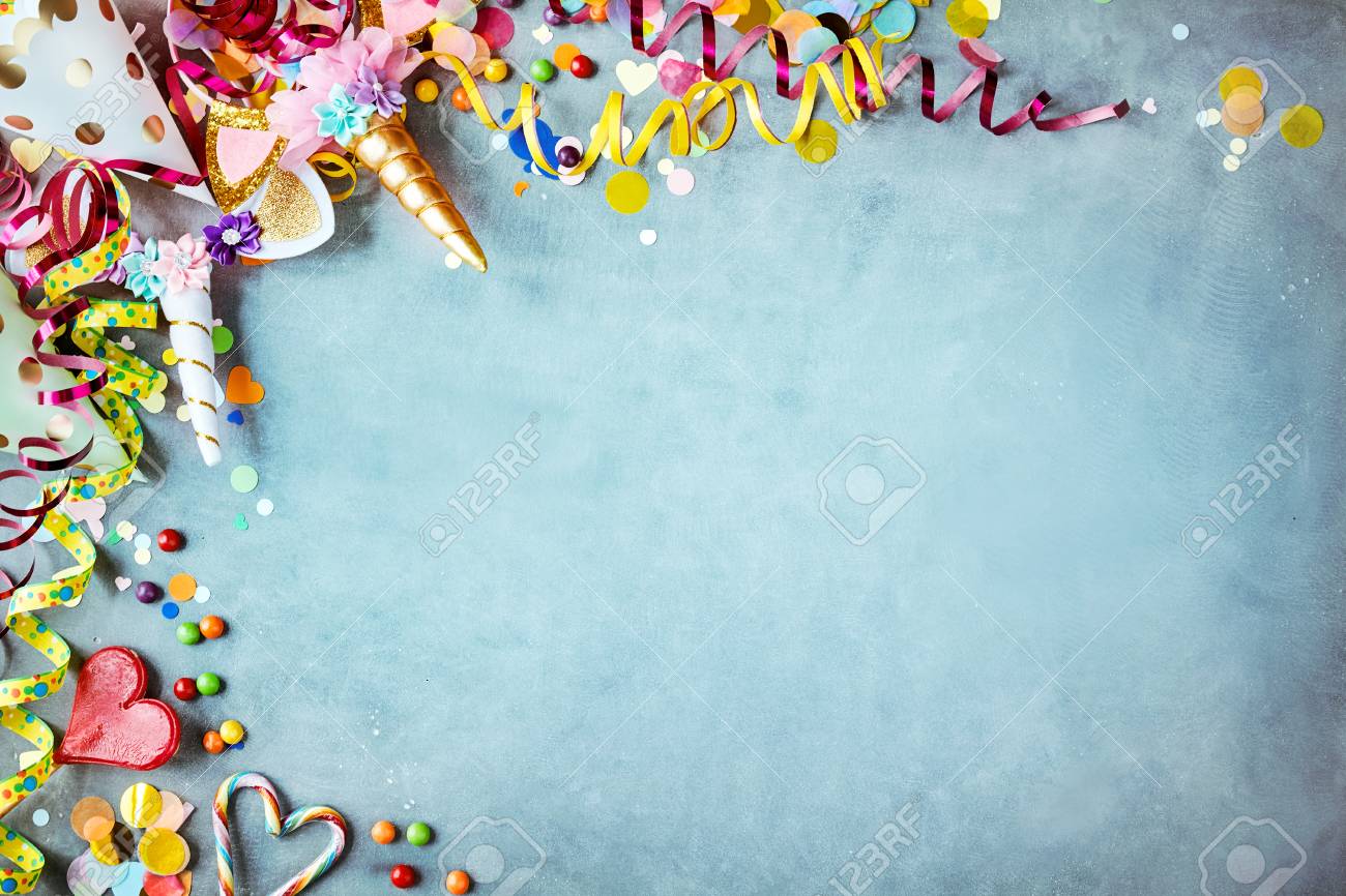 Colorful unicorn carnival border over a cool blue textured background with copy space with party hats, candy, streamers and hearts - 108238231 Colorful unicorn carnival border over a cool blue textured background with copy space with party hats, candy, streamers and hearts - 108238231