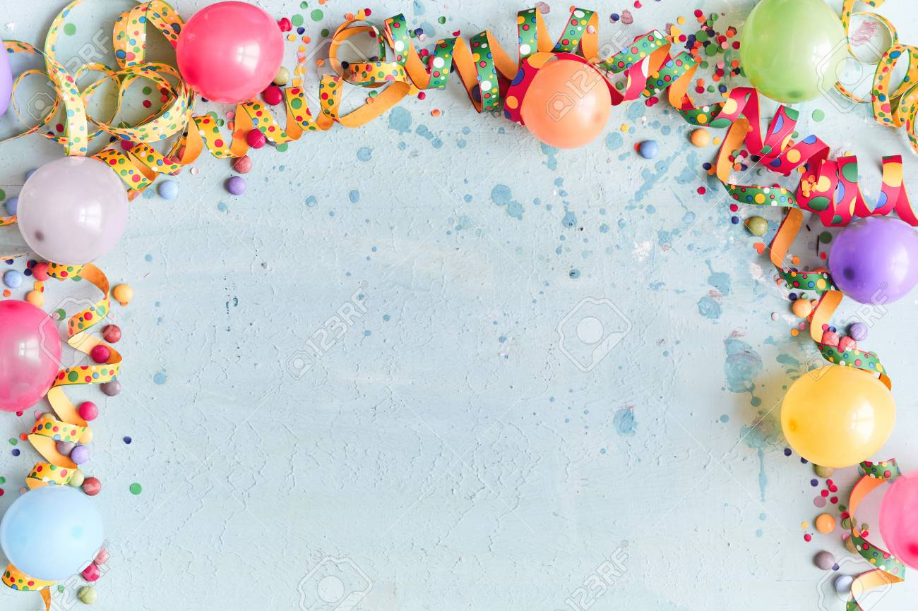 Carnival, festival or birthday balloon background with colorful party streamers, candy and confetti making a border on a blue background with copy space - 110130273 Carnival, festival or birthday balloon background with colorful party streamers, candy and confetti making a border on a blue background with copy space - 110130273
