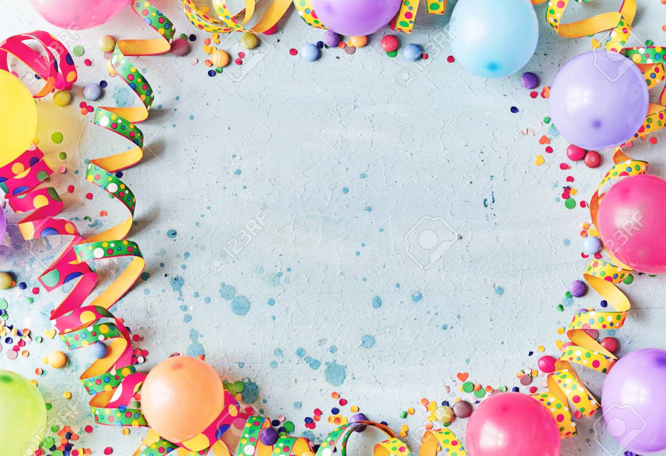 Multicolored carnival or birthday background on blue with a frame of colorful party balloons, streamers, confetti and candy around central copy space - 110130431 Multicolored carnival or birthday background on blue with a frame of colorful party balloons, streamers, confetti and candy around central copy space - 110130431