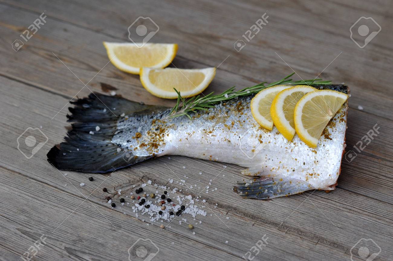 生の魚尻尾サーモン レモンとローズマリーの木製の背景 の写真素材 画像素材 Image