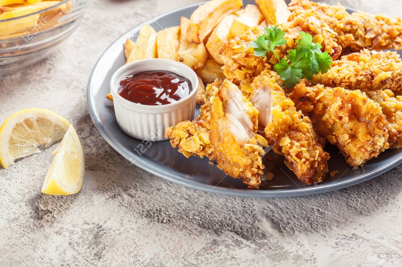 Chicken strips in cornflakes breadcrumb served with french fries - 144030053 Chicken strips in cornflakes breadcrumb served with french fries - 144030053