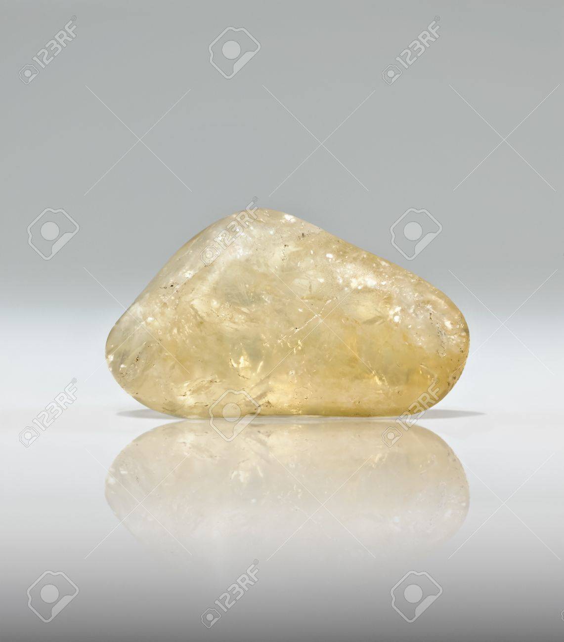 白い背景とシトリンの宝石は 光沢のある表面に反映されます シトリン 心の石 と呼ばれているし 幸運な商人 石 として知られていますいます 売り上げ高の任意の種類の場合は ちょうど現金引き出しで シトリンを置くし 何 Happe を見る の写真素材 画像素材