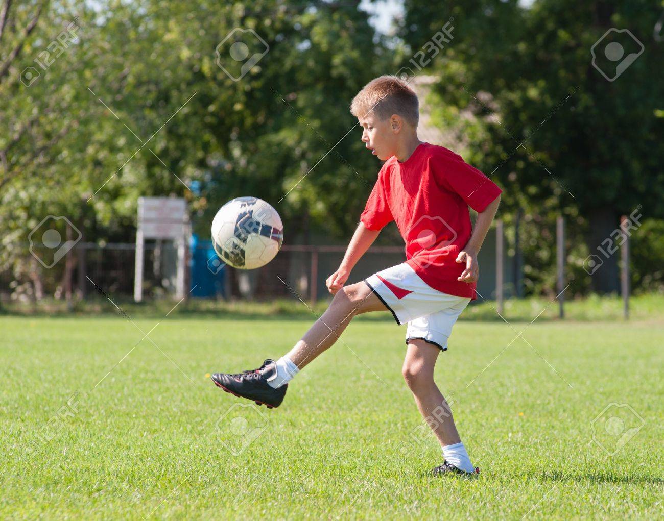boy kicking football on