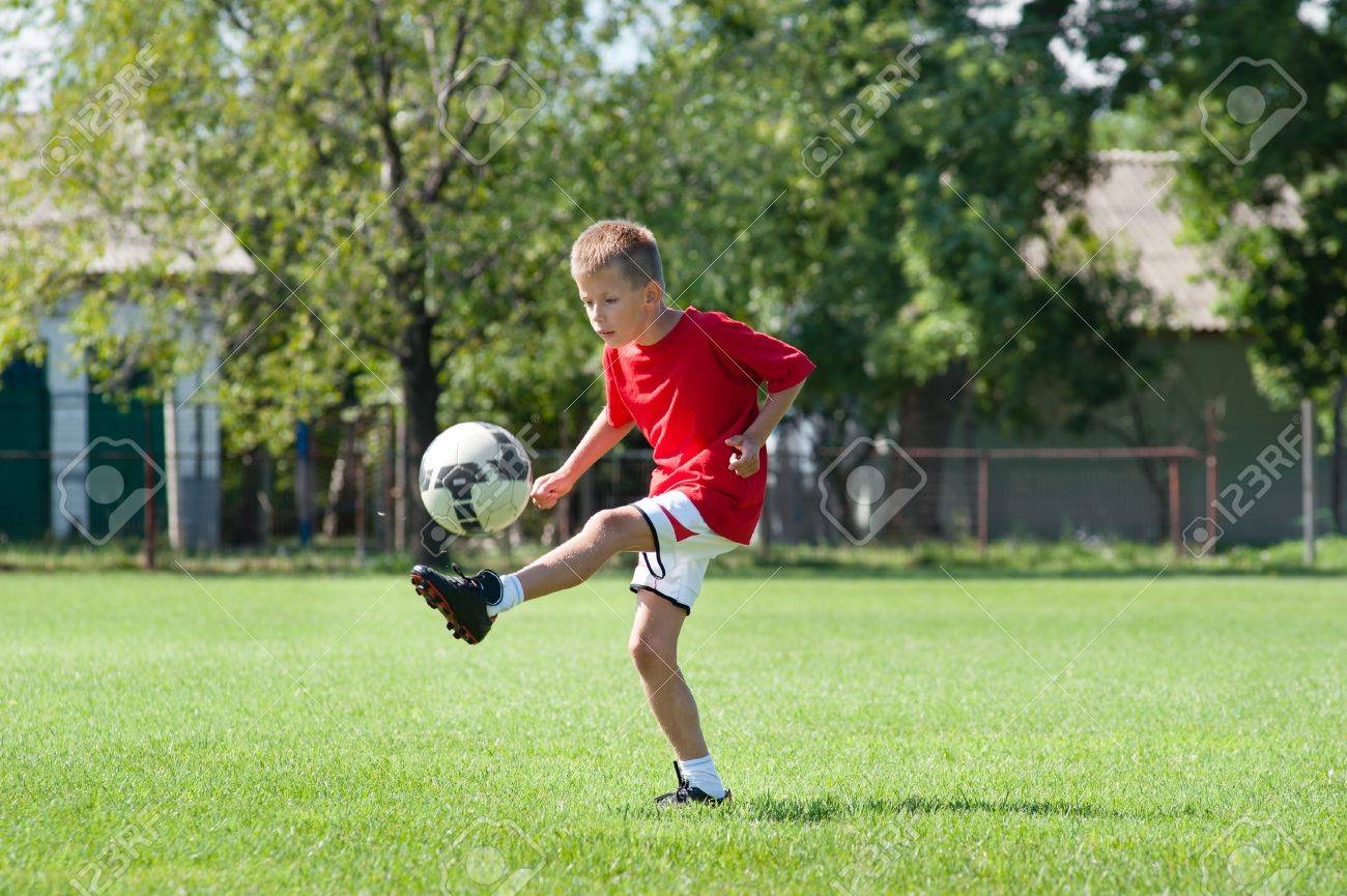 boy kicking football on