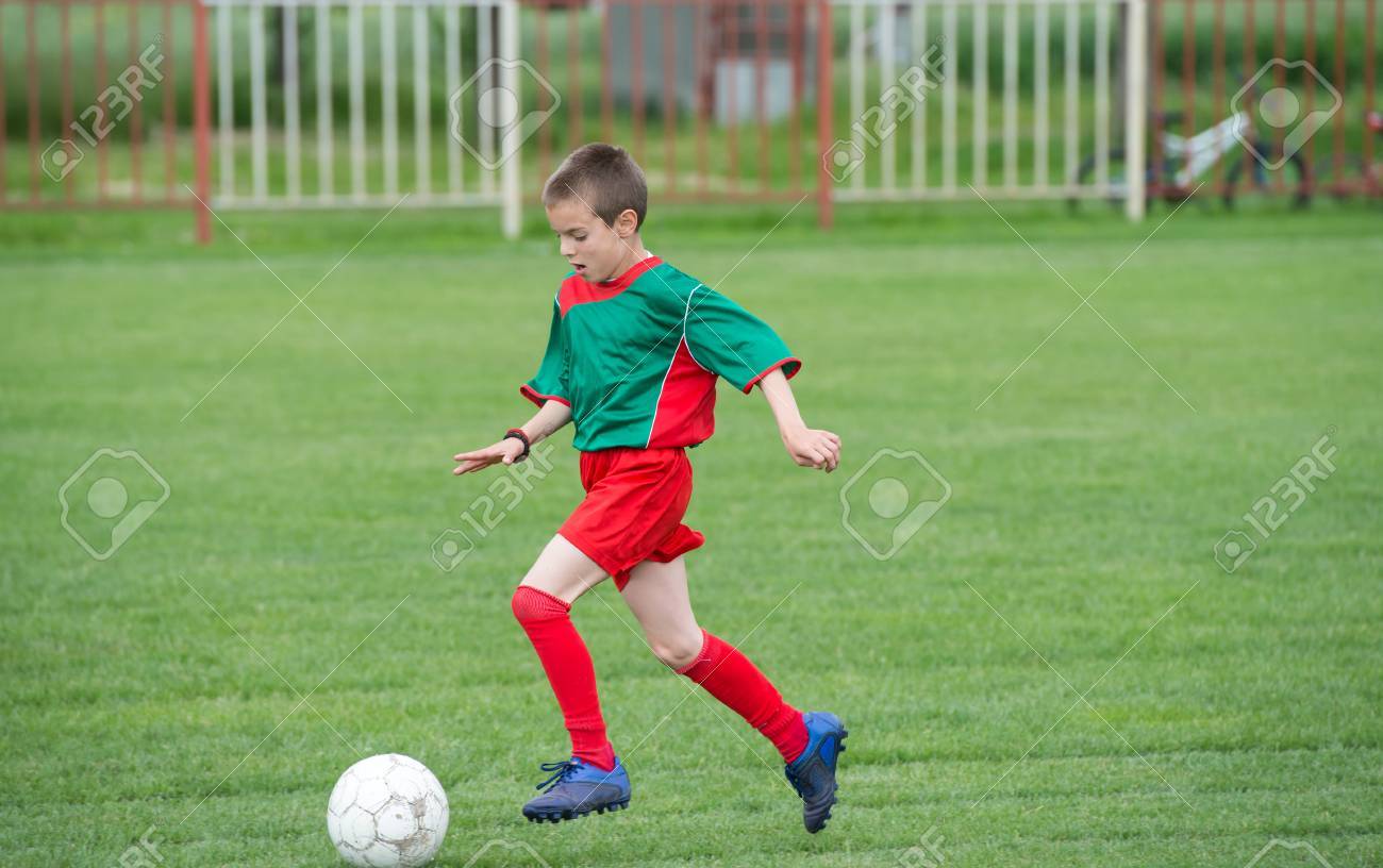 boy kicking football on