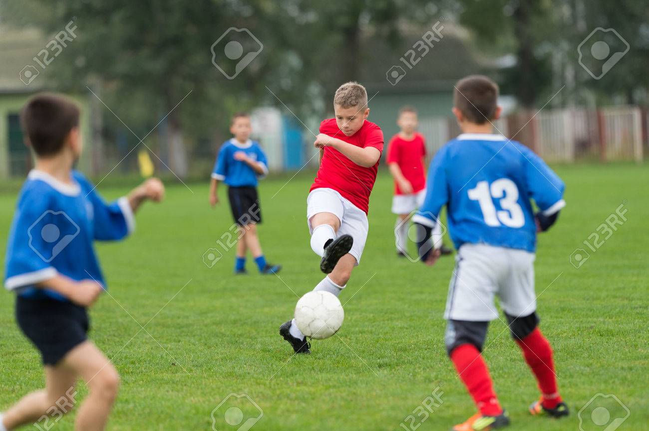 boy kicking football on
