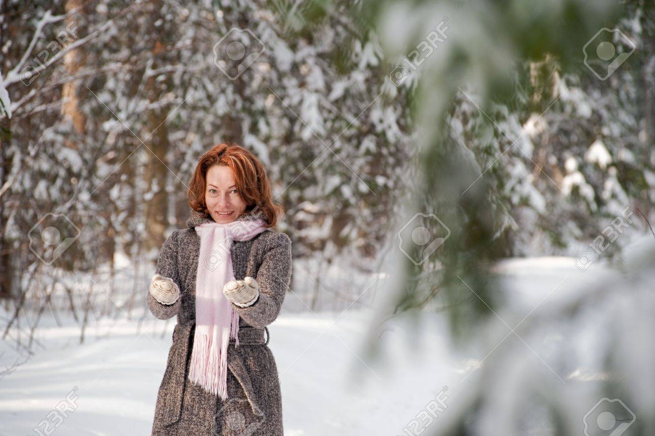 happy red haired woman having fun on winters day in forest stock