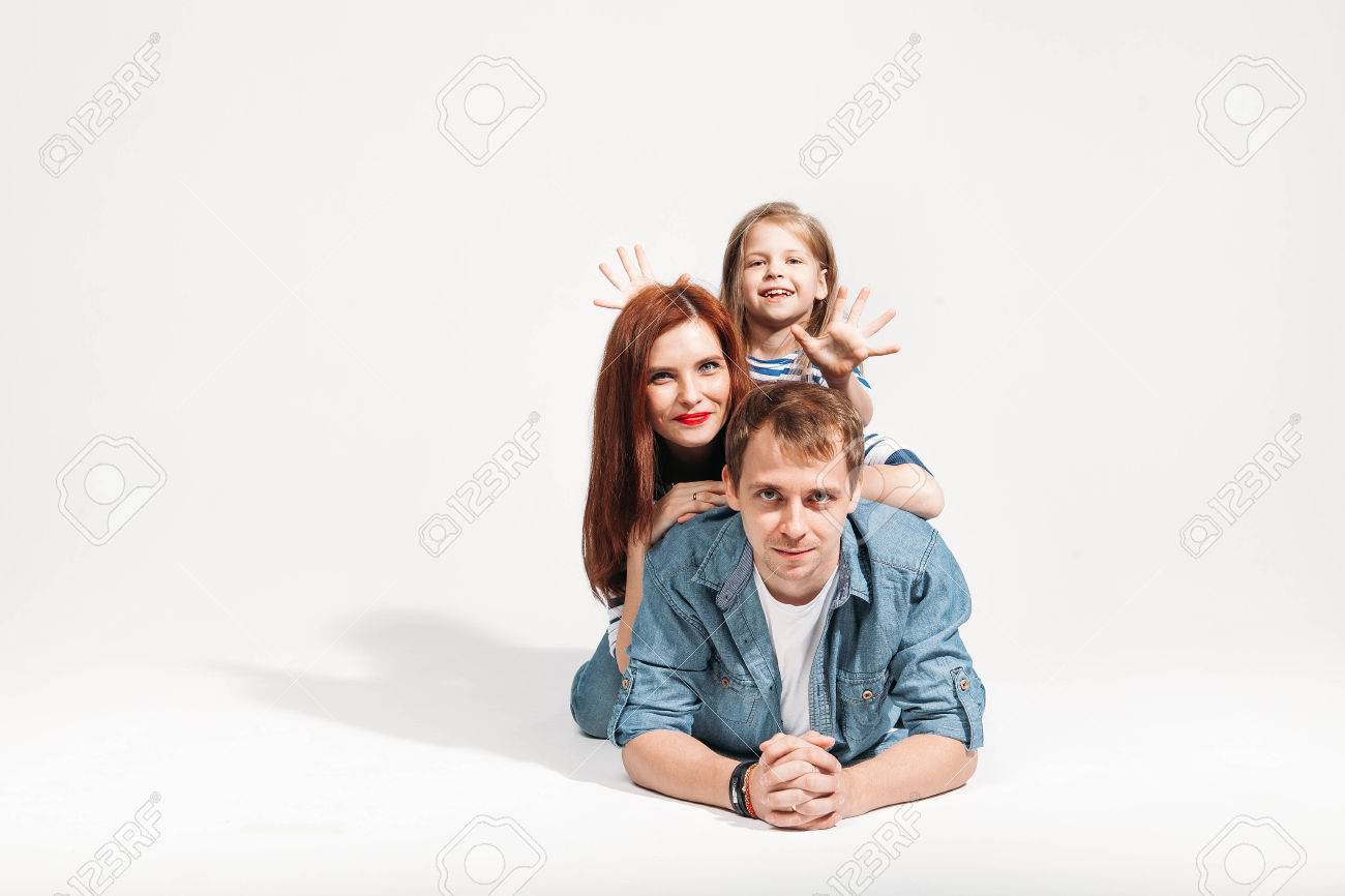父親の背中に分離した白い背景に横たわっている幸せな面白い家族の肖像画 の写真素材 画像素材 Image