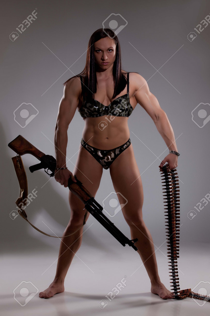 Young woman holding a machinegun - 166429225 Young woman holding a machinegun - 166429225