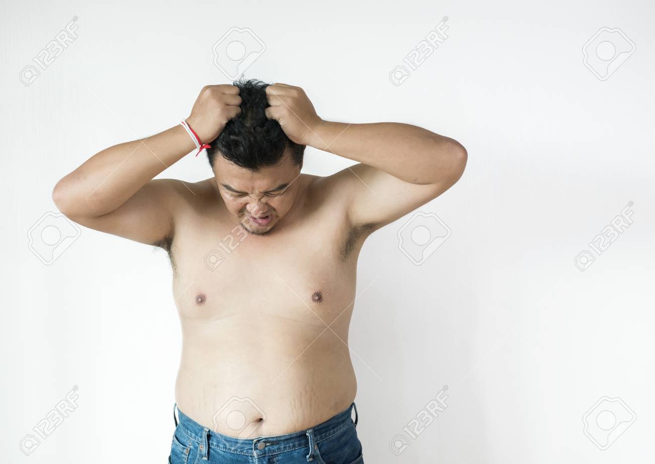 太った男はシャツを着ない 白いバックグローンに 服を着て試着する太りすぎの男 コピースペース の写真素材 画像素材 Image