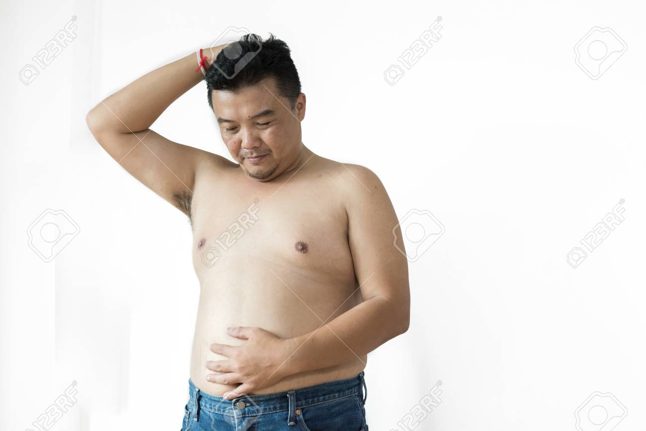 太った男はシャツを着ない 白いバックグローンに 服を着て試着する太りすぎの男 コピースペース の写真素材 画像素材 Image
