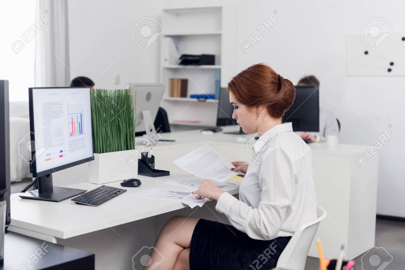 A Young Accountant In The Office Examines Accounting Financial Tax Reports In The Office Of A Commercial Company. Mockup Monitor Stock Photo, Picture And Royalty Free Image. Image 154869612.