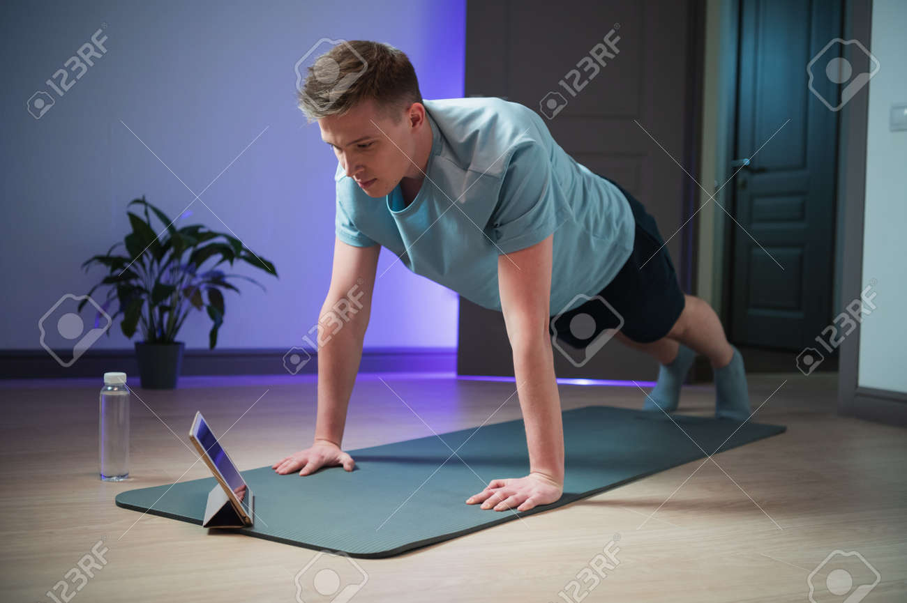 Online training of a young athlete at home on the mat, a professional coach conducts a class on the Internet - 170401011 Online training of a young athlete at home on the mat, a professional coach conducts a class on the Internet - 170401011