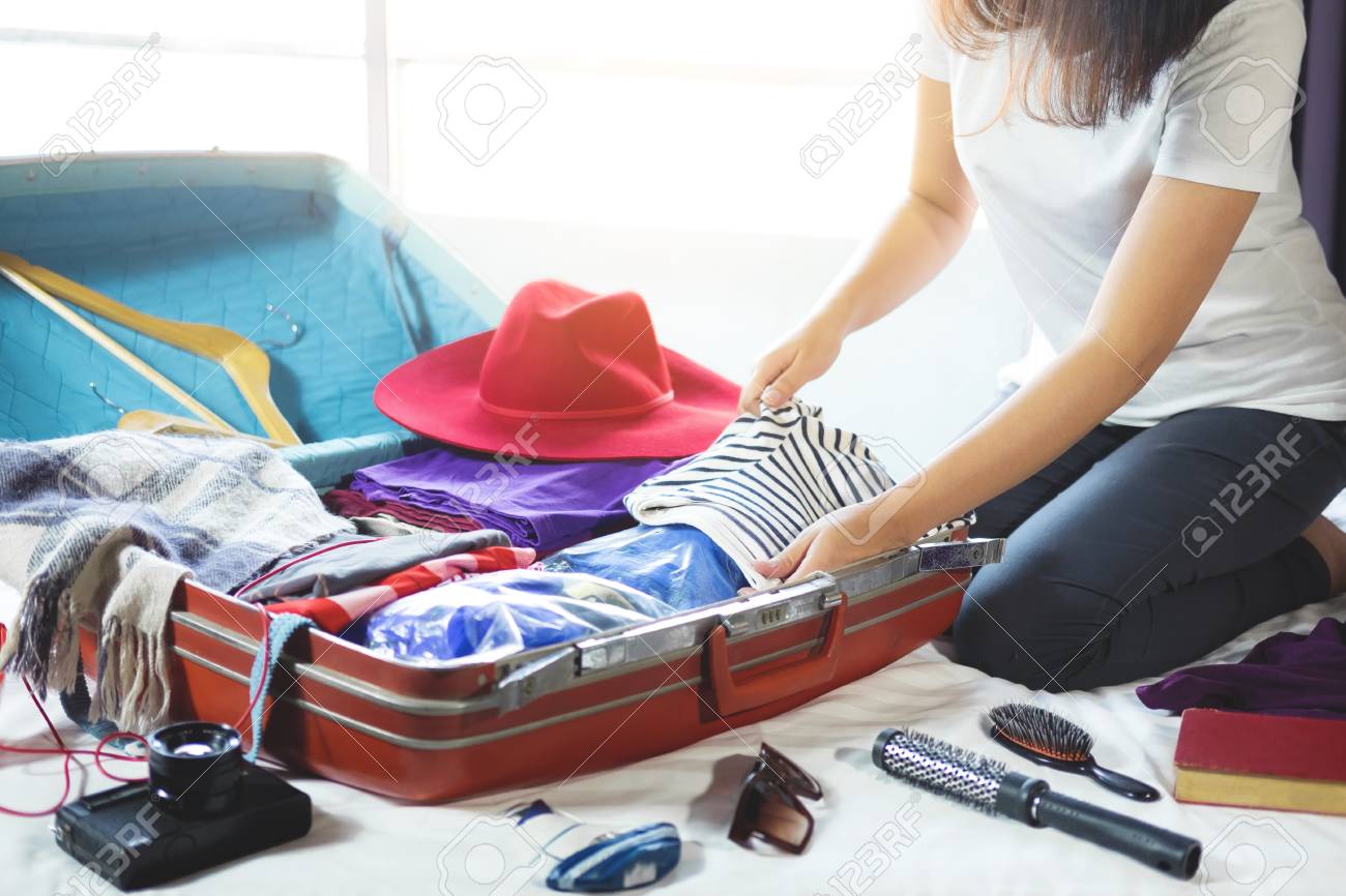 travel and vacation concept happiness young woman packing a stock