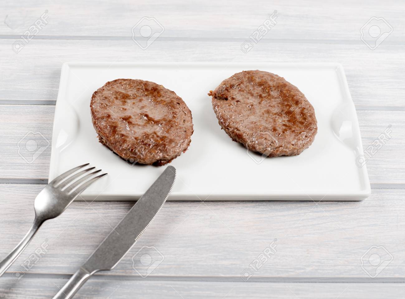 ナイフとフォークを木製のテーブルの横にある白いプレートのハンバーガー 食品 の写真素材 画像素材 Image ナイフとフォークを木製のテーブルの横にある白いプレートのハンバーガー 食品 の写真素材 画像素材 Image