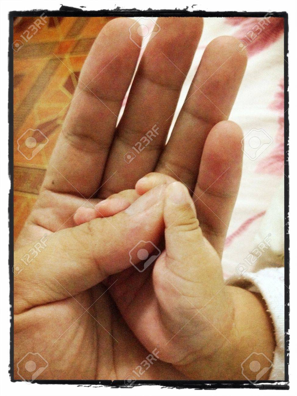 赤ちゃんの手手に汗握るダディスグルーブ親指 の写真素材 画像素材 Image