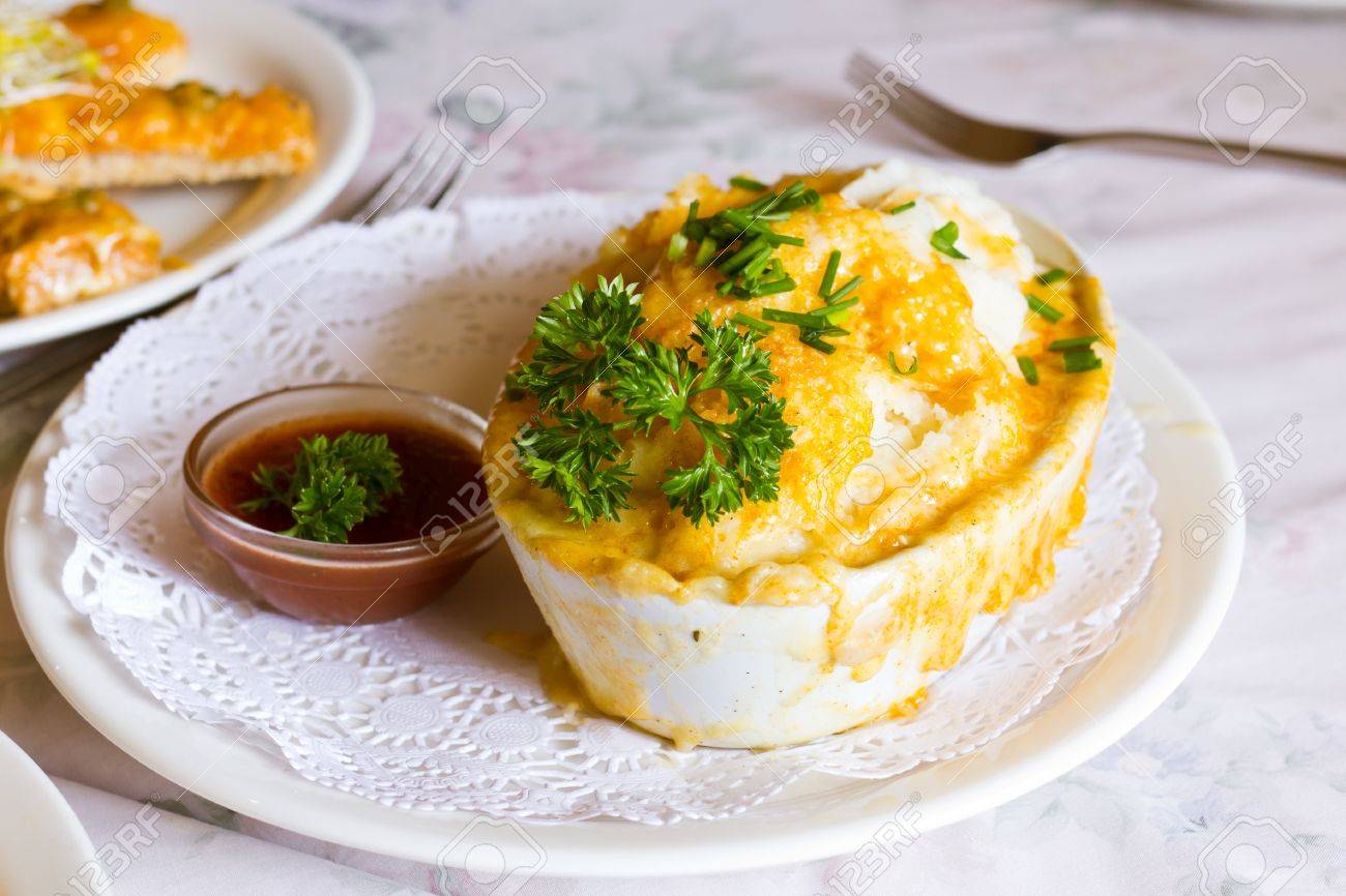オーブン焼きグルメ鶏羊飼いパイ新鮮なトマトソースと緑の付け合わせを添えてください の写真素材 画像素材 Image
