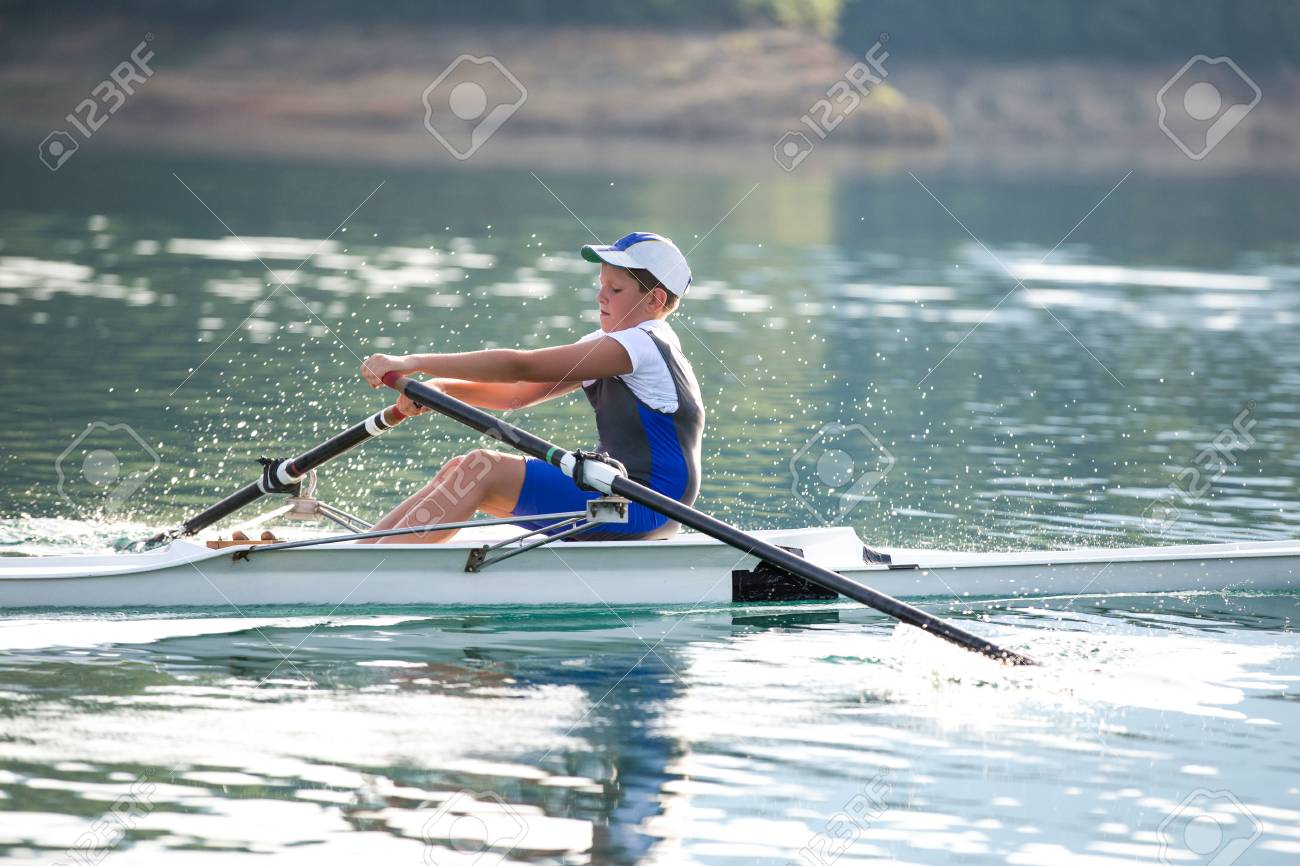 静かな湖でライバル パドルを漕ぐ若いシングル スカル の写真素材 画像素材 Image