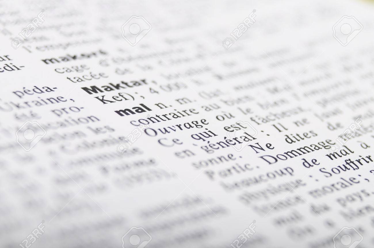 close up of french dictionary at the word mal equal to evil or word mal