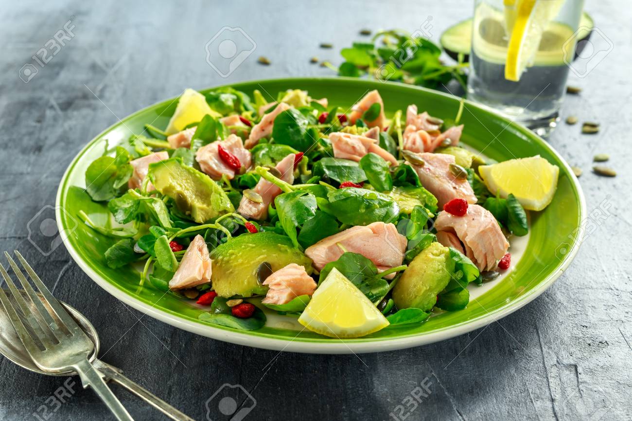 Healthy Salmon, Avocado salad with watercress and goji berries, pumpkin seed mix on green plate - 73562313 Healthy Salmon, Avocado salad with watercress and goji berries, pumpkin seed mix on green plate - 73562313