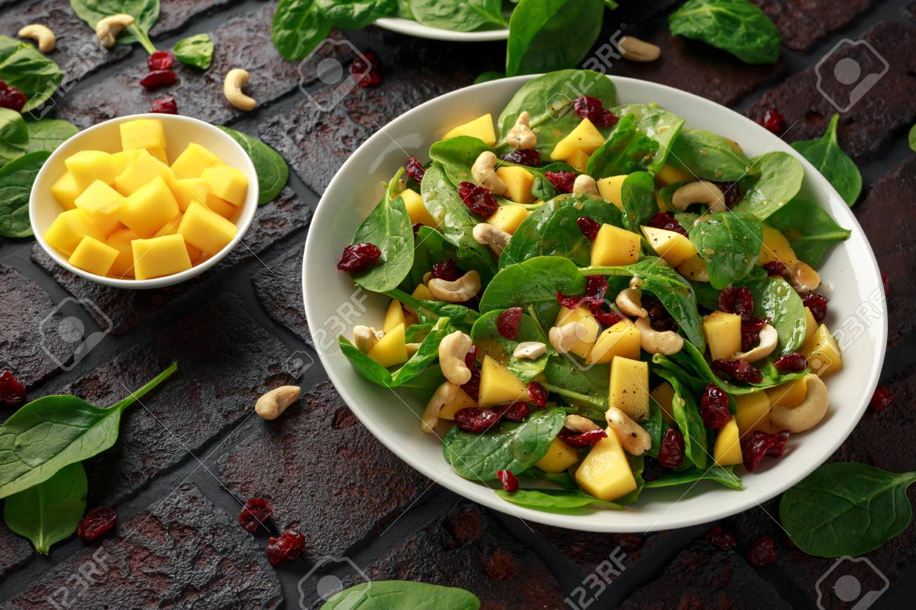 Mango Spinach salad with dried cranberries and nuts. healthy food. - 117671120 Mango Spinach salad with dried cranberries and nuts. healthy food. - 117671120