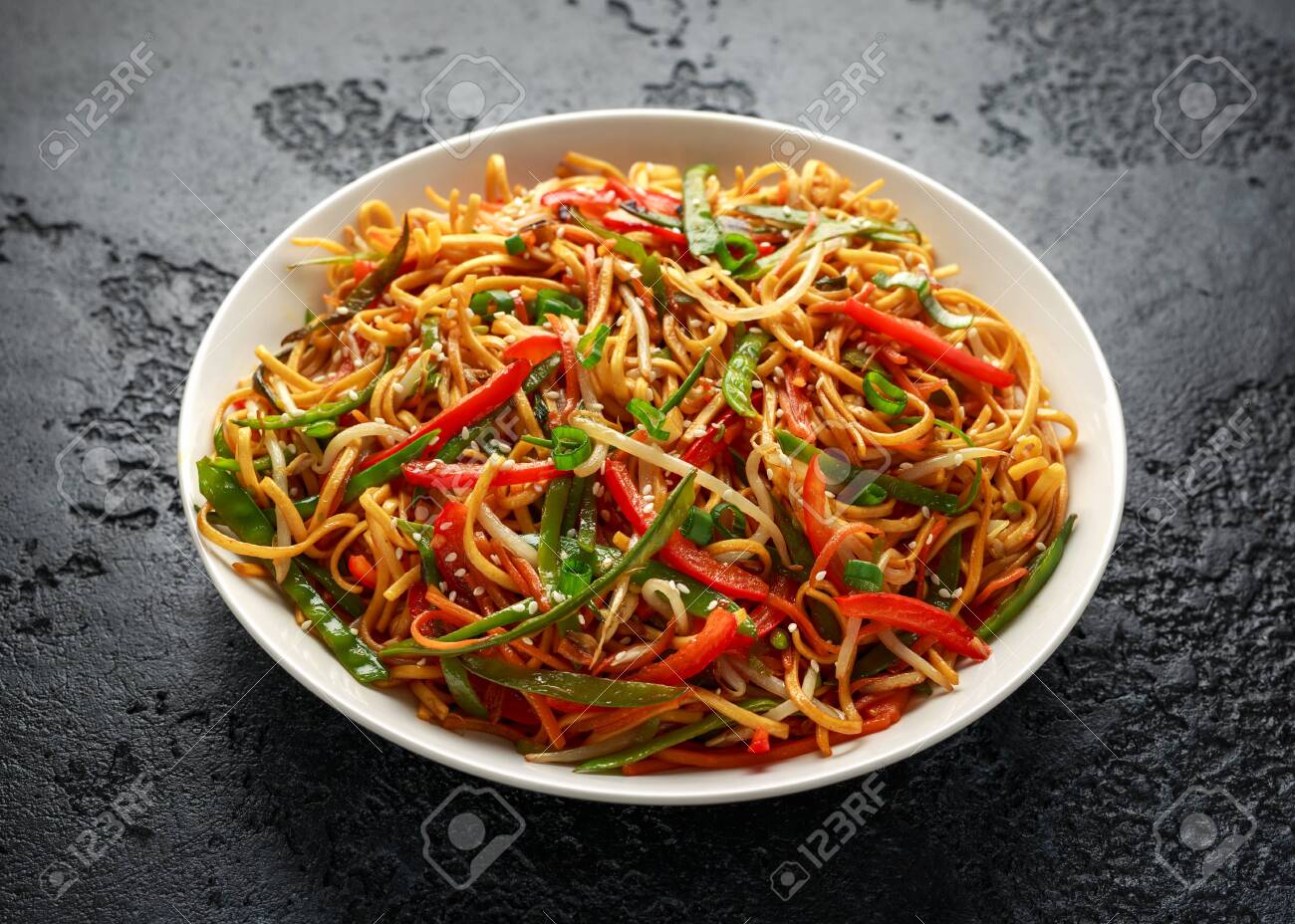 Chow mein, noodles and vegetables dish with wooden chopsticks - 123674904 Chow mein, noodles and vegetables dish with wooden chopsticks - 123674904
