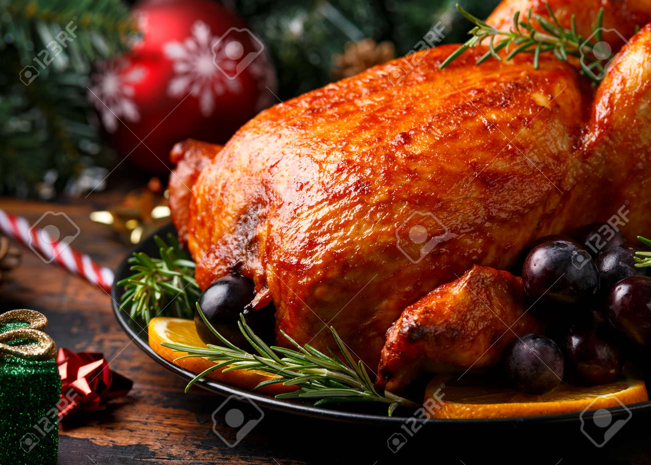 Christmas Chicken, roast in oven with decoration, gifts, green tree branch on wooden rustic table - 158220625 Christmas Chicken, roast in oven with decoration, gifts, green tree branch on wooden rustic table - 158220625
