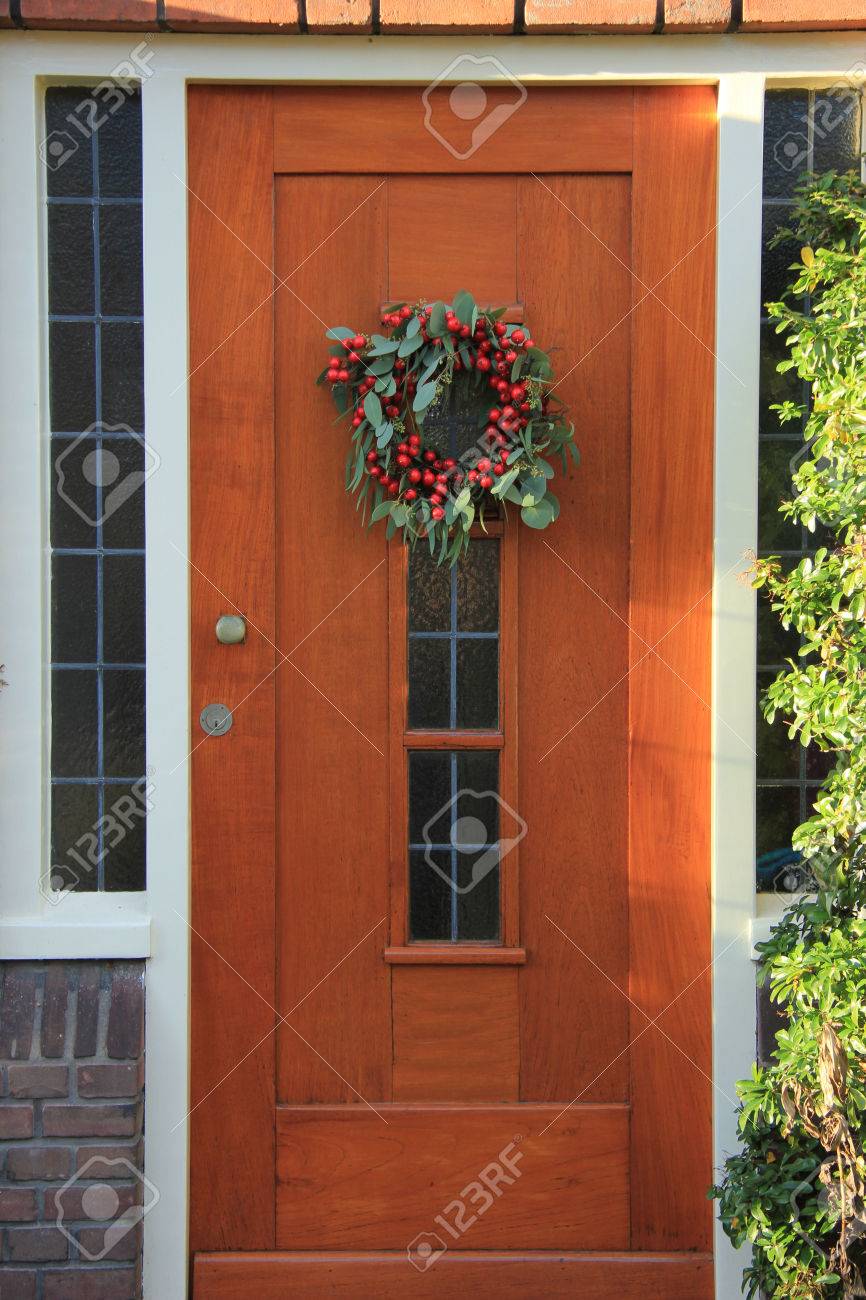 Berry christmas wreath with decorations on a door - 38610073 Berry christmas wreath with decorations on a door - 38610073