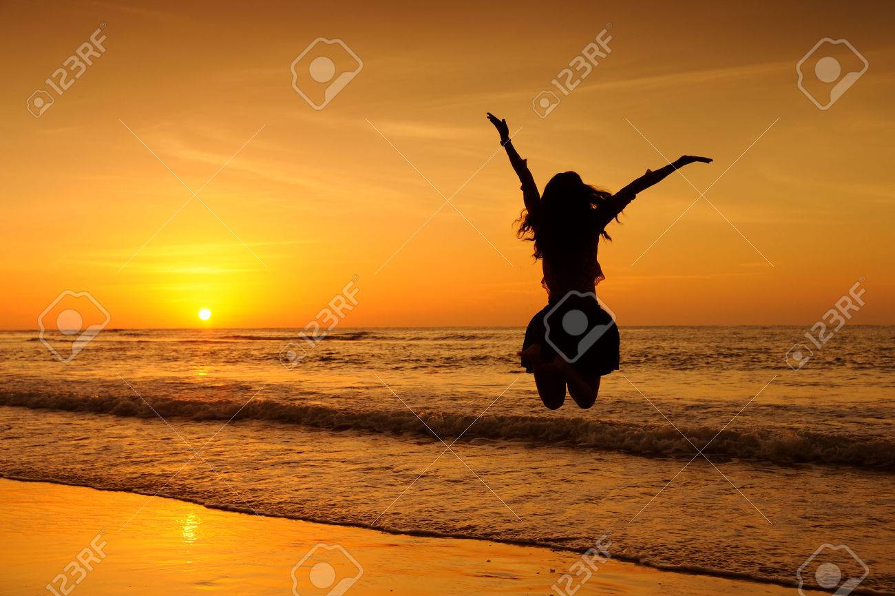 海の夕日にジャンプ幸せな女 の写真素材 画像素材 Image