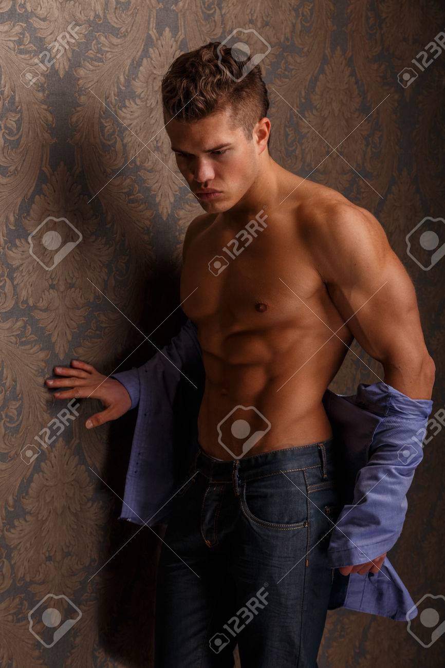 壁を越えて彼のマッチョな体とポーズを見せて男のファッション ポートレート の写真素材 画像素材 Image