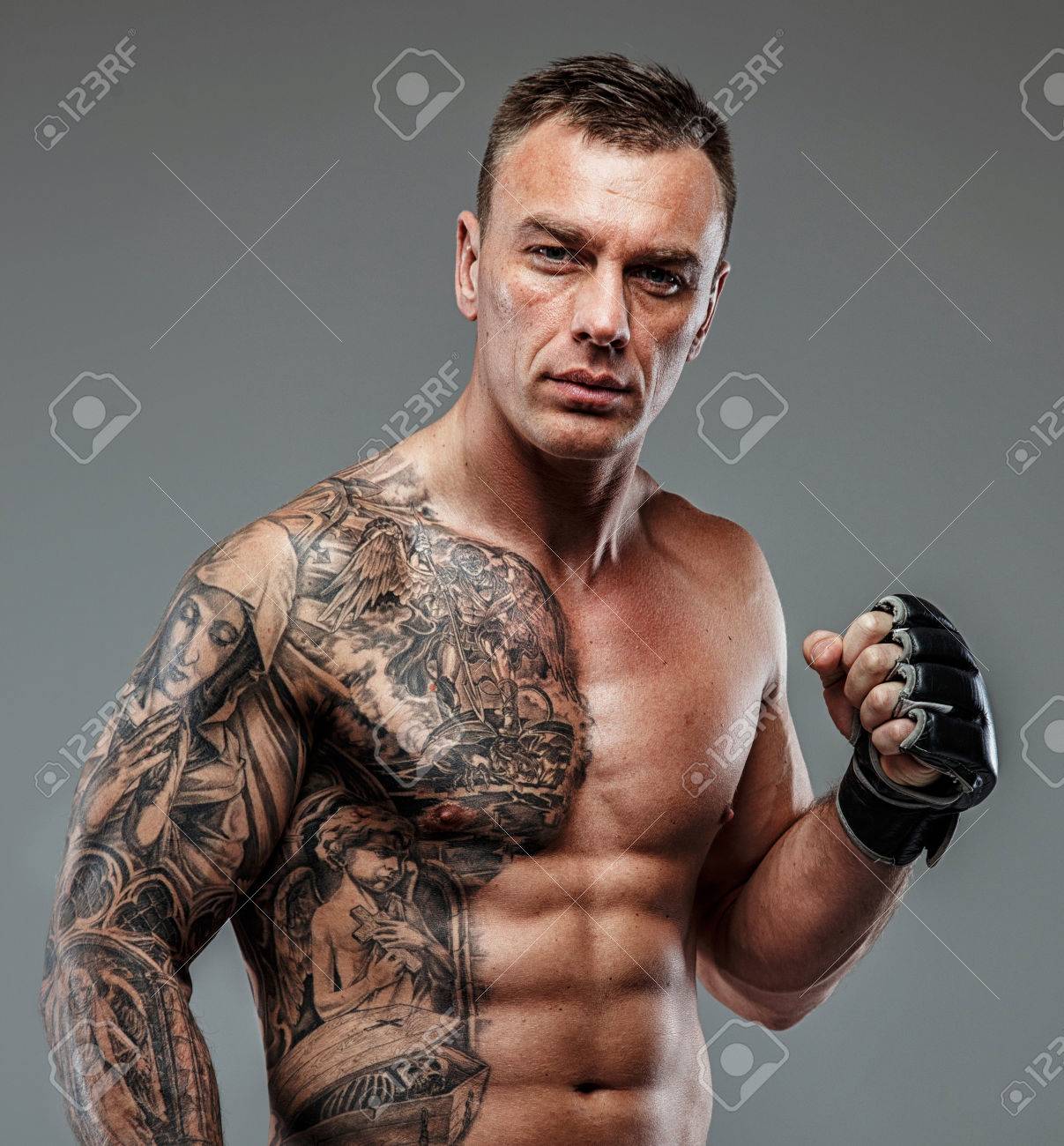 Strong muscular fighter with tattoo poses - 38249048 Strong muscular fighter with tattoo poses - 38249048