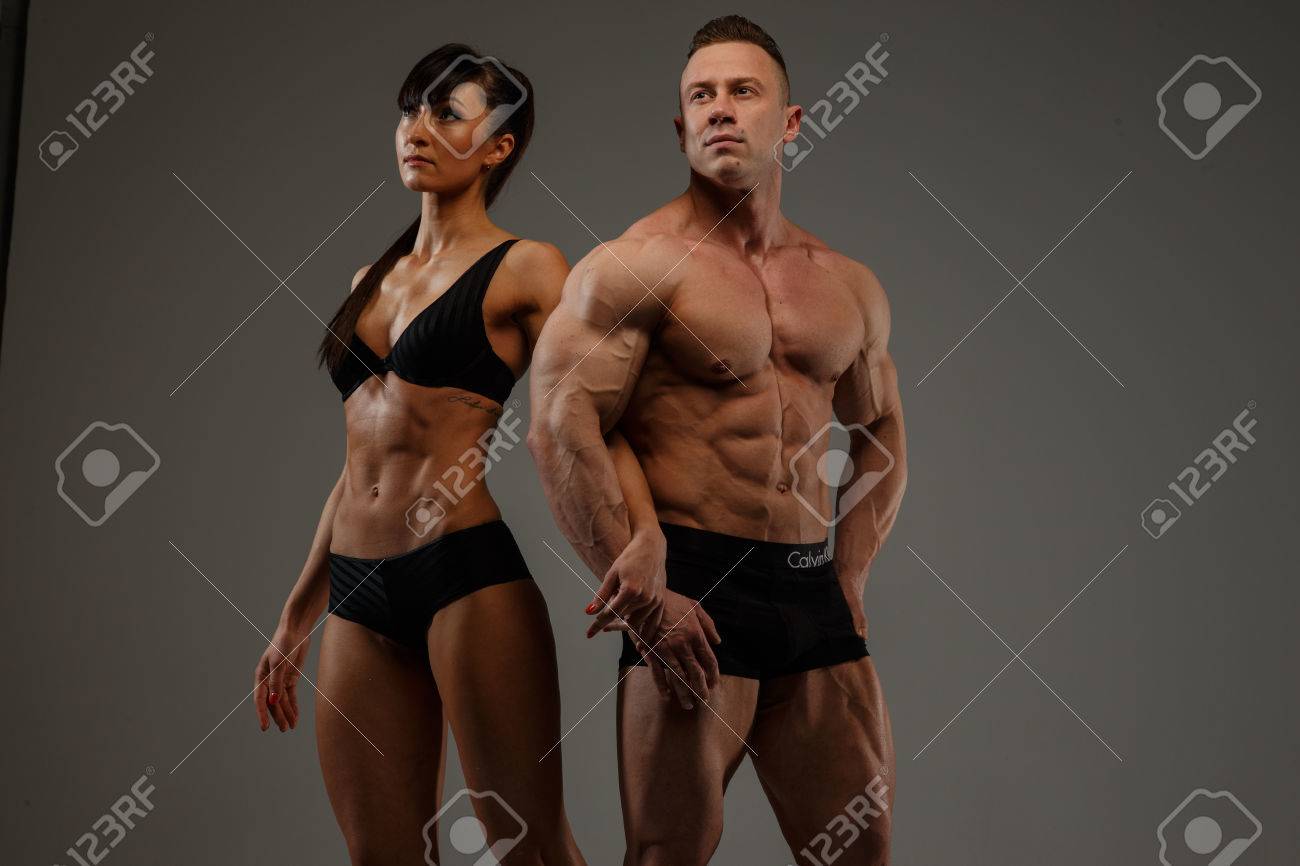 下着姿でフィットネス女性と男性ボディービルダーのカップル 灰色の背景上に分離 の写真素材 画像素材 Image
