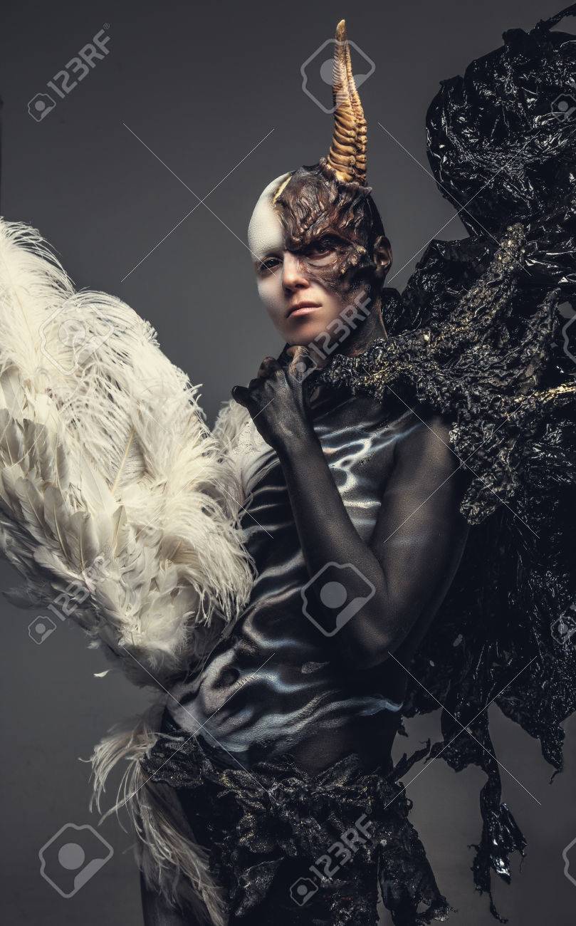 Portrait of devil woman in black and white clothes with one horn on her head. Isolated on grey background. - 48628264 Portrait of devil woman in black and white clothes with one horn on her head. Isolated on grey background. - 48628264